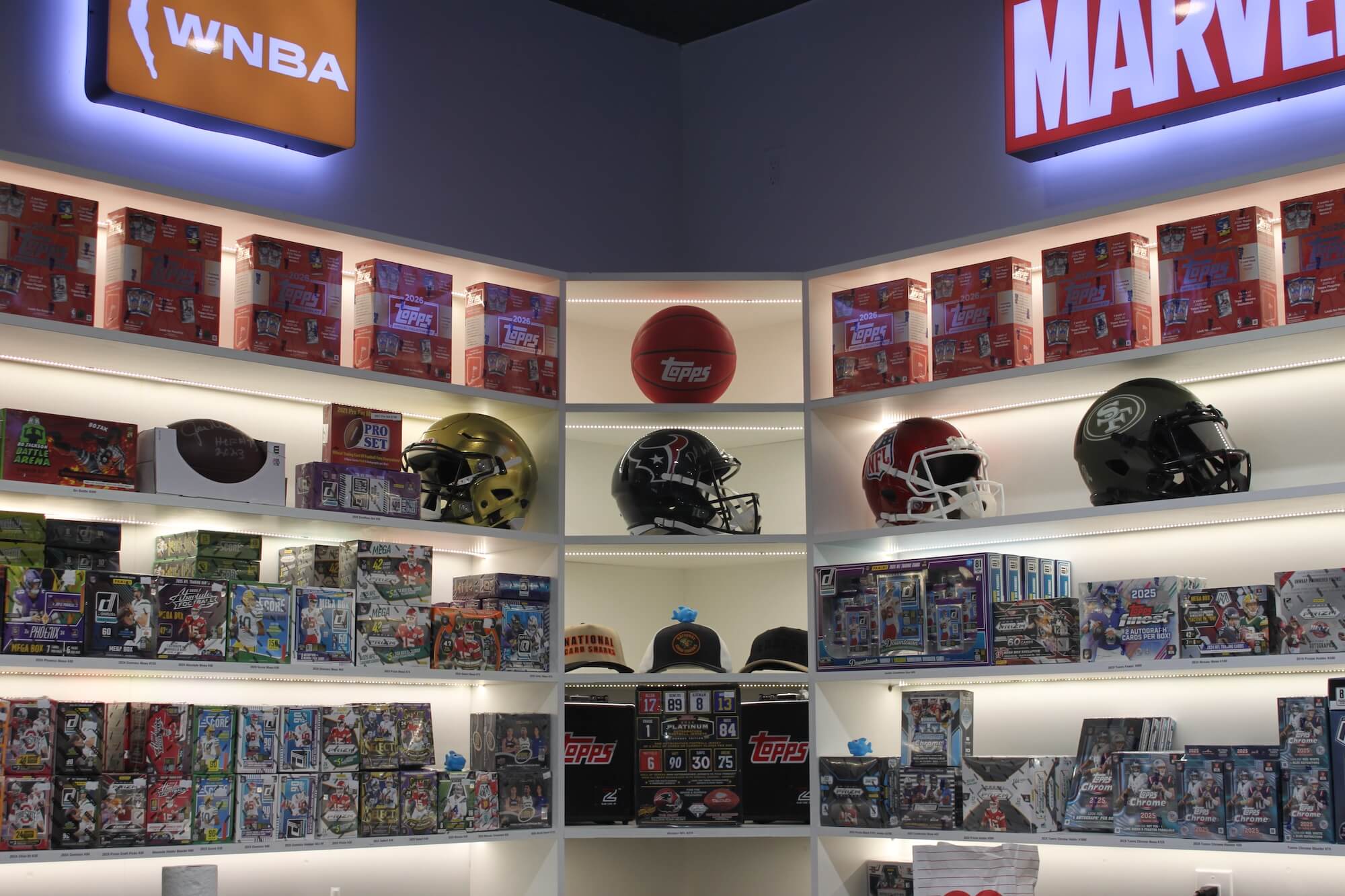 NCS store interior with sports-themed collectibles and branded logos on a dark wall.